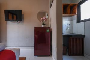 a room with a small refrigerator with a vase of flowers at RedDoorz near Mertasari Beach 2 in Pesanggaran