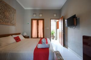 a bedroom with a bed and a flat screen tv at RedDoorz near Mertasari Beach 2 in Pesanggaran