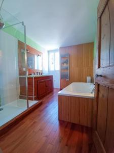 une grande salle de bain avec baignoire et douche dans l'établissement Maison de Village 18ème Siècle Familiale 3 Chambres, à Mus