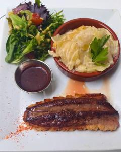 a plate of food with a steak and a salad at Cit Hotel Noemys Gradignan - ex Le Chalet Lyrique in Gradignan