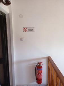 a fire extinguisher on a wall with a sign on it at THE PALM ROOMs in Preveza +8 photos