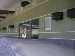 ein grünes Gebäude mit einem Seitenfenster in der Unterkunft Hotel do Prado in Petrópolis