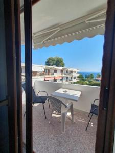 a patio with a table and chairs on a balcony at Paralia Homes Ocean Postcard in Kriopigi