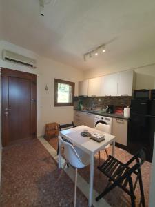 a kitchen with a table and two chairs and a table at Paralia Homes Ocean Postcard in Kriopigi