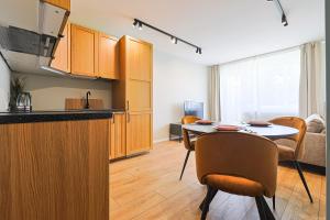 a kitchen and dining room with a table and chairs at ᴄᴏʜᴏsᴛ I 2BD Apartment With Balcony in Mažeikiai