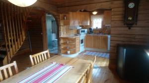 a kitchen with a table in a log cabin at Härbre i Höga Kusten, Ullånger in Ullanger