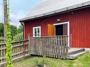 a red house with a wooden fence in front of it at 4 star holiday home in SVÄNGSTA in Svängsta