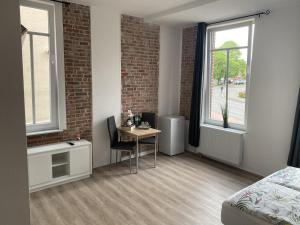 a bedroom with a desk and a bed and a window at Appartementhaus EMDEN in Emden