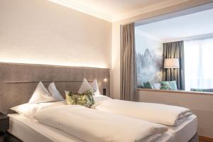 a hotel room with two beds with white pillows at Rauriserhof 4 Sterne Superior in Rauris