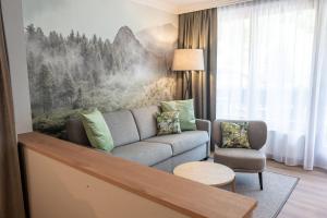 a living room with a couch and a chair at Rauriserhof 4 Sterne Superior in Rauris