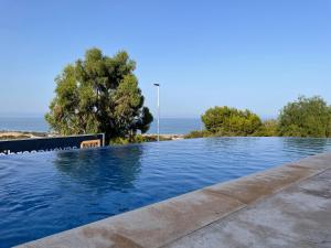 une piscine avec l'océan en arrière-plan dans l'établissement Nova SuperBeach 38, à Gran Alacant