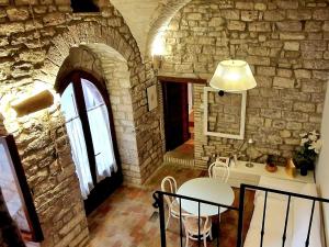 a kitchen with a table and a stone wall at Brizi 5 in Assisi