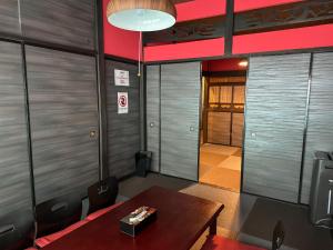 a meeting room with a table and chairs and a red ceiling at TRAVELERZ YOKOHAMA Demon Slayer House in Kikuna