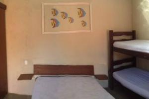 una camera con due letti a castello e una foto a parete di Linda Casa em Boiçucanga - São Sebastião, 4 suítes a São Sebastião Altre 24 foto