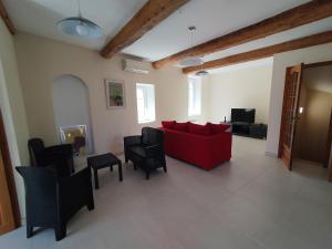 a living room with a red couch and chairs at Les 27 in Ginestas