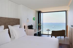 a bedroom with a large bed with a view of the ocean at Les Vagues Hotel & Spa in Arcachon