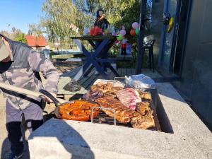 a person is cooking food on a grill at Cabañas y Padel Tinycolchagua cl in Santa Cruz