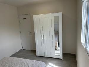 a white cabinet with a mirror in a bedroom at New modern apartment, Scandinavian style, ocean view, huge terrace in Icod de los Vinos