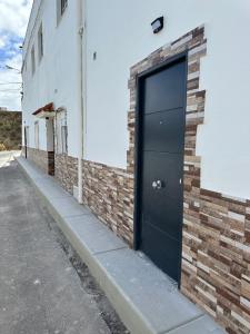 a black door on the side of a brick building at New modern apartment, Scandinavian style, ocean view, huge terrace in Icod de los Vinos