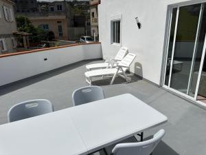 a white table and chairs on a balcony at New modern apartment, Scandinavian style, ocean view, huge terrace in Icod de los Vinos