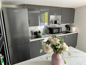 a kitchen with a vase of flowers on a counter at New modern apartment, Scandinavian style, ocean view, huge terrace in Icod de los Vinos