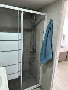 a shower with a glass door and a blue towel at New modern apartment, Scandinavian style, ocean view, huge terrace in Icod de los Vinos