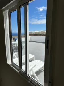 an open window with a view of a patio at New modern apartment, Scandinavian style, ocean view, huge terrace in Icod de los Vinos