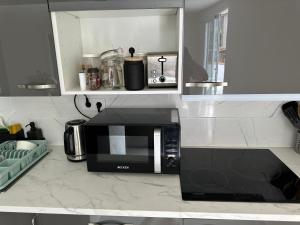 a kitchen with a black microwave in a kitchen at New modern apartment, Scandinavian style, ocean view, huge terrace in Icod de los Vinos