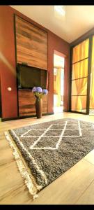 a living room with a rug and a vase with flowers at LOFT in Down Town in Dnipro