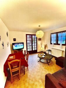 a living room with a table and a couch at Au pays d'Hector Berlioz in La Côte-Saint-André