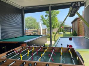 a pool table in a room next to a window at Domki nad morzem Park Jesionów in Pleśna