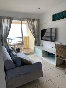 a living room with a couch and a flat screen tv at Beach Village - Praia do Futuro II in Fortaleza