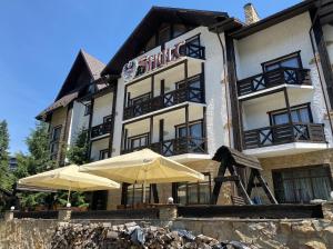 ein Hotel mit zwei Sonnenschirmen davor in der Unterkunft Shulc in Bukowel