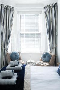 a bedroom with a bed and two chairs and a window at Portsmouth Apartment *Newly refurbished *Central in Portsmouth