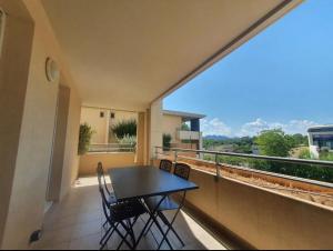 a balcony with a table and chairs and a view at Location d’un Superbe appartement avec piscine in Roquebrune-sur-Argens