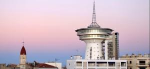 una torre de control con una antena en la parte superior de un edificio en Appartement avec cour à côté de la plage, en Palavas-les-Flots