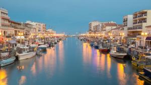 Un grupo de barcos atracados en un canal con edificios en Appartement avec cour à côté de la plage, en Palavas-les-Flots
