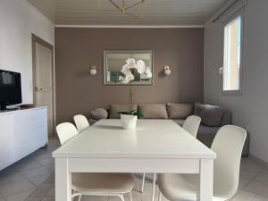 una mesa blanca y sillas en la sala de estar. en Appartement avec cour à côté de la plage, en Palavas-les-Flots