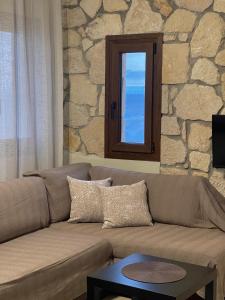 a living room with a couch and a window at Villa Sunrise in Agia Paraskevi +30 photos