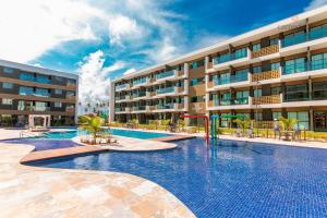 a swimming pool in front of a building at Mana Beach Experience Muro Alto By Carpediem in Porto De Galinhas