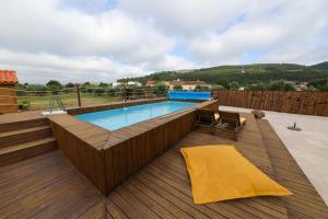 a swimming pool on a wooden deck with a wooden deck at Renovated Wine Press House - WITH POOL in Porto de Mós
