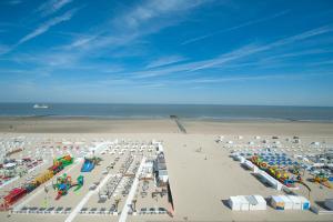 an aerial view of a beach with chairs and umbrellas at Beach Hotel Helios by CW Hotel Collection in Blankenberge