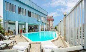 a swimming pool in front of a building at Bano Palace Hotel in Douala