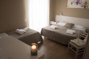 a room with two beds and a candle on a table at Anna Guest House in Rome