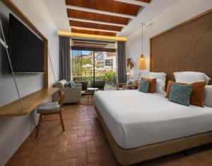 a bedroom with a large bed and a living room at Cala San Miguel Ibiza Resort, Adults only, Curio Collection by Hilton in Puerto de San Miguel