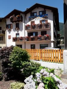 a building with balconies and flowers in front of it at Casa Salvaterra Affittacamere in Pinzolo