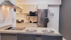 a kitchen with a refrigerator and two wine glasses at Book Santos - Unlimited 618 - Veja e escute o Mar in Santos +37 photos