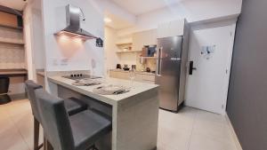 a kitchen with a counter and a refrigerator at Book Santos - Unlimited 618 - Veja e escute o Mar in Santos