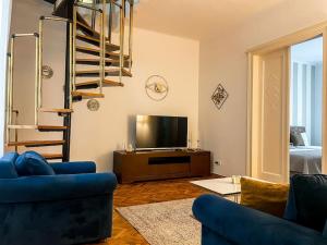 Una sala de estar con un sofá azul y un televisor. en Sweet House Skadarlija, en Belgrado