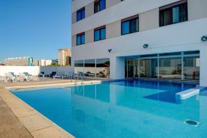 a swimming pool in front of a building at VIP Executive Zurique Hotel in Lisbon